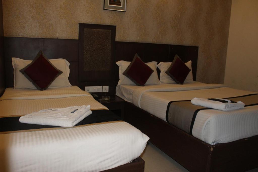 Postel nebo postele na pokoji v ubytování SKY GATE HOTEL Near Apollo MAIN, Women's & Children's US Consulate Sankara Netralaya Goethe Institute PrestigePalladium Shastri Bhavan Senmozhi Poonga Raj Ratnam Stadium TAJ Coromandal India Oil Bhavan Dr Mohan's Diabetics VAC Chennai
