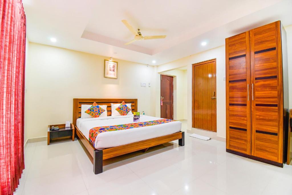 a bedroom with a bed and a dresser at FabHotel Sri Krishna Residency Airport in Chennai