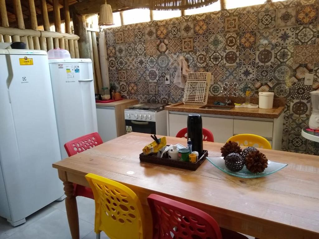 a kitchen with a wooden table with chairs and a tableasteryasteryasteryasteryastery at Condomínio Summer House, Itacimirim in Itacimirim