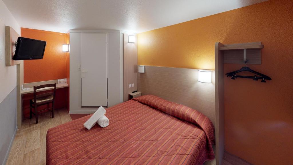 a bedroom with a bed and a desk and a television at Premiere Classe Cambrai Proville in Cambrai