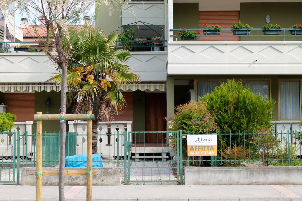 a building with a palm tree in front of it at Nettuno 53 in Grado