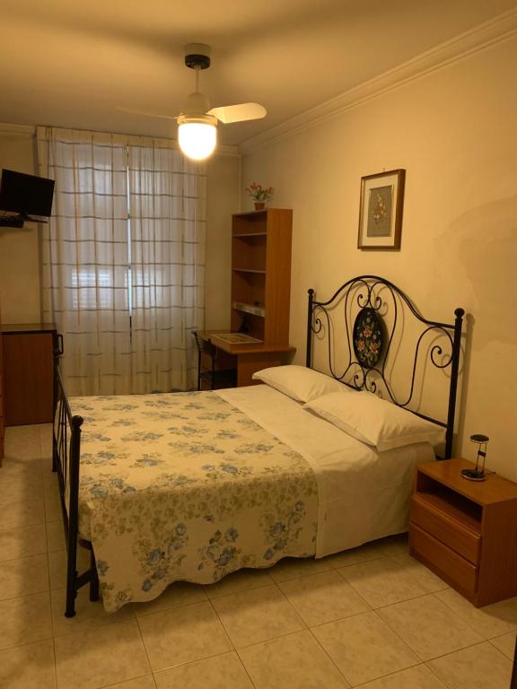 a bedroom with a bed and a table and a lamp at HOTEL ELENA in Turin