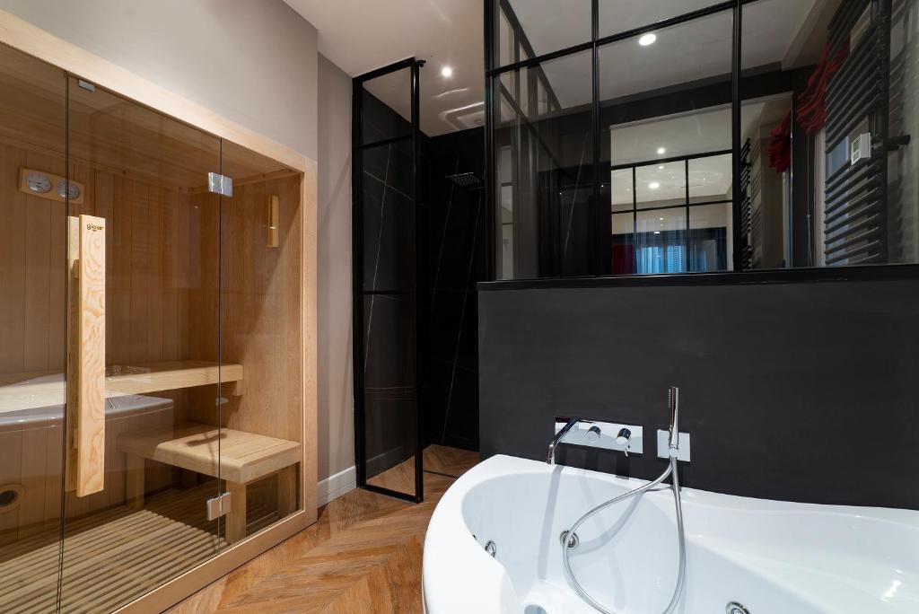 a bathroom with a tub and a glass shower at Artemide Guest House in Florence