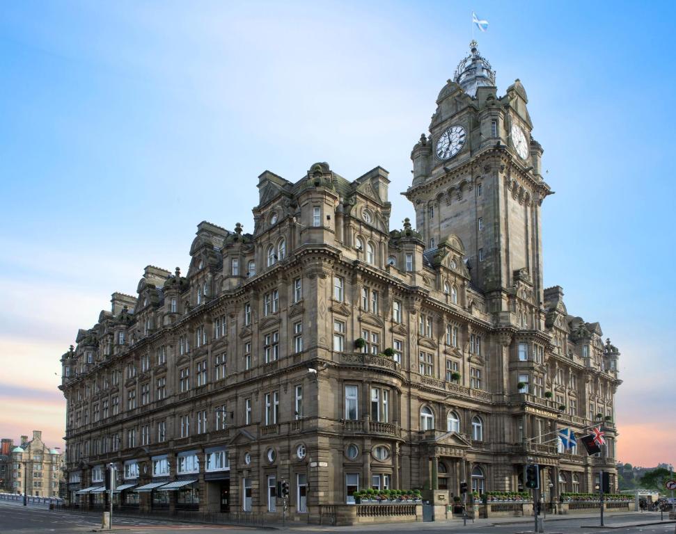 ein großes Gebäude mit einem Uhrturm darüber in der Unterkunft The Balmoral Hotel in Edinburgh