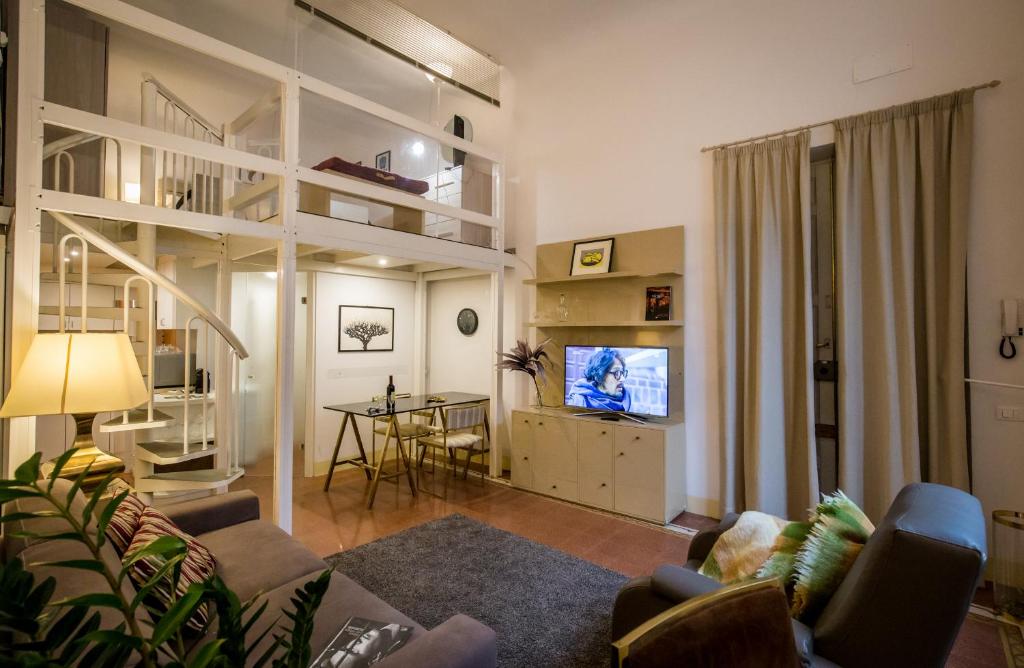 a living room with a couch and a tv at Acacia Firenze - Calla in Florence