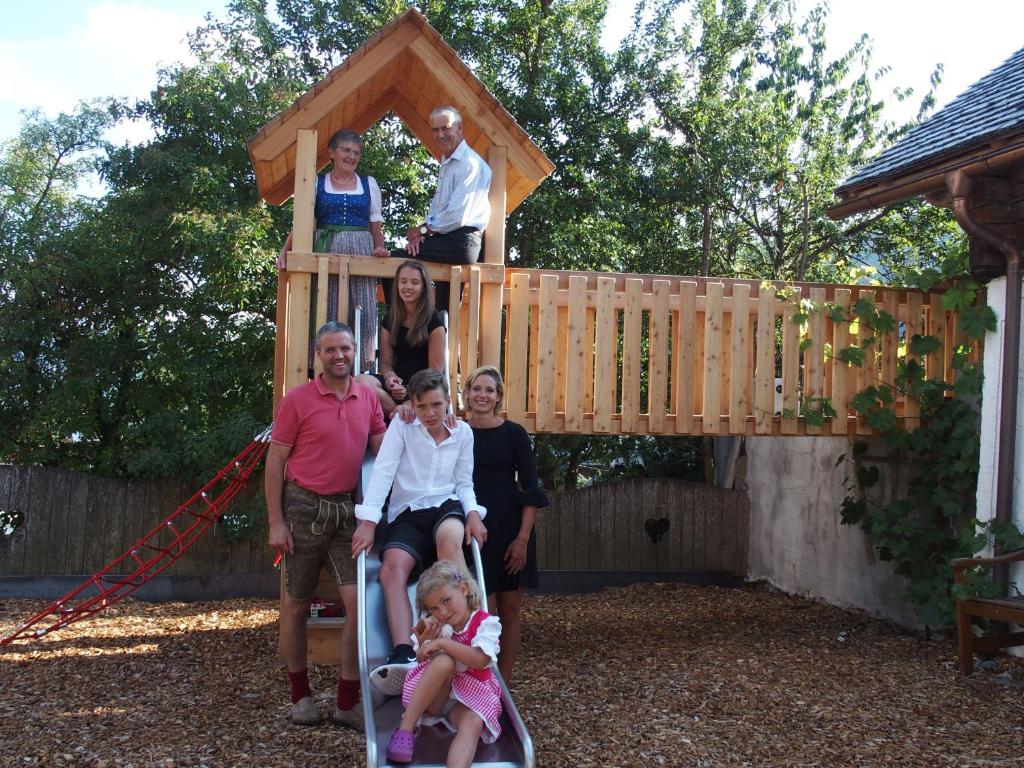 a family posing in front of a play structure at Dorfergut in Weisspriach
