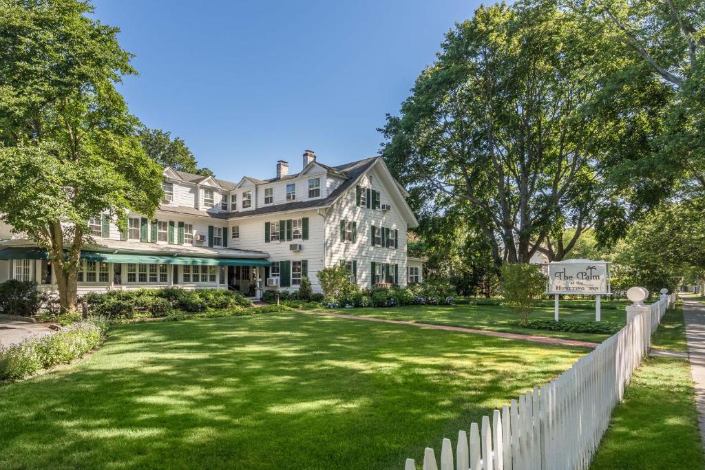 a large white house with a white fence at The Huntting Inn in East Hampton