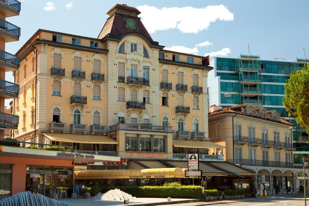 a large building with a clock on top of it at Hotel Victoria in Lugano