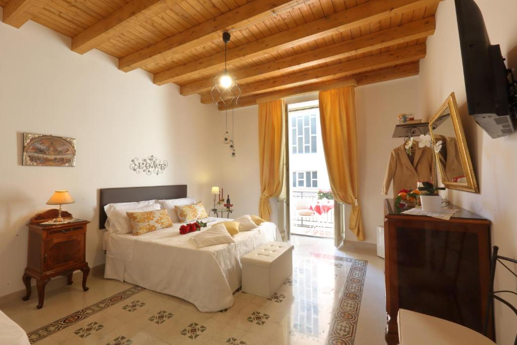 una camera con letto e TV di "Suliscenti" Dimora Siciliana B&B ad Avola
