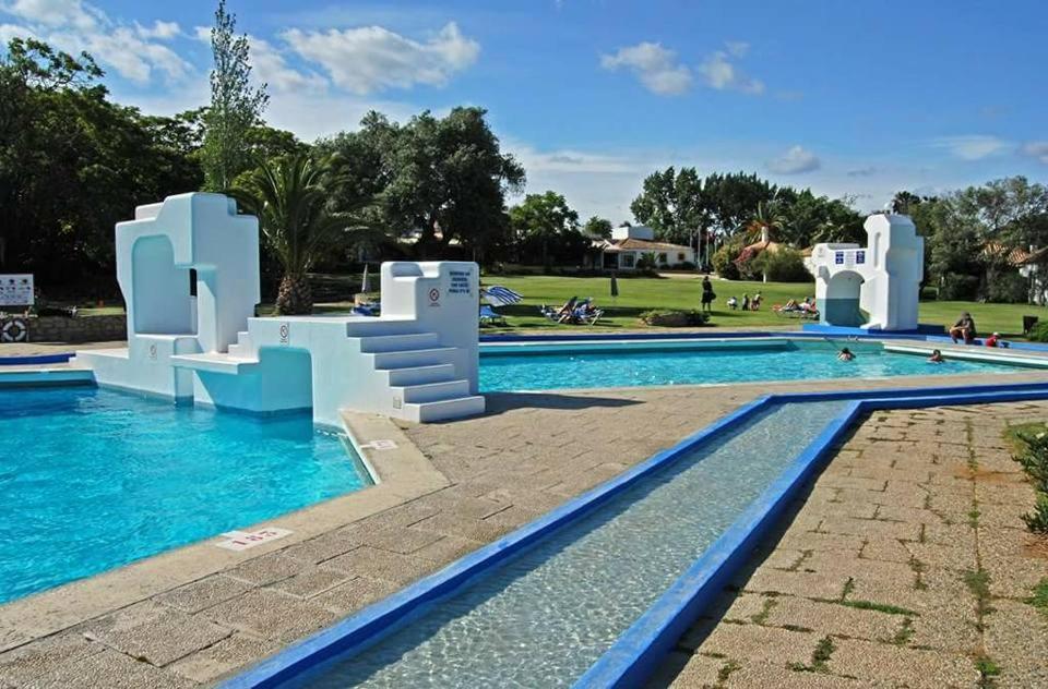 a large swimming pool with a water slide in a park at Pedras D'el Rei - Vista Jardim in Tavira