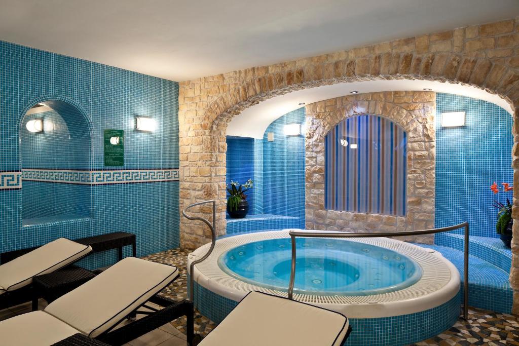 a bathroom with a tub with chairs in it at Le Querce Resort Sea Thermae & Spa in Ischia
