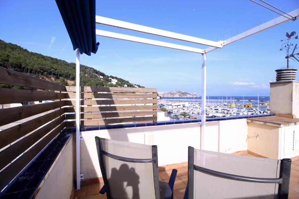 balcón con 2 sillas y vistas al puerto en Sistachrentals Atic Port, en L'Estartit