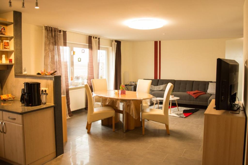 eine Küche und ein Wohnzimmer mit einem Tisch und Stühlen in der Unterkunft Ferienwohnung Frau Klara in Hofheim in Unterfranken