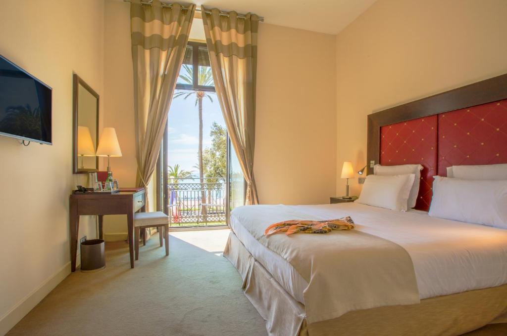 a hotel room with a large bed and a window at Westminster Hotel & Spa Nice in Nice