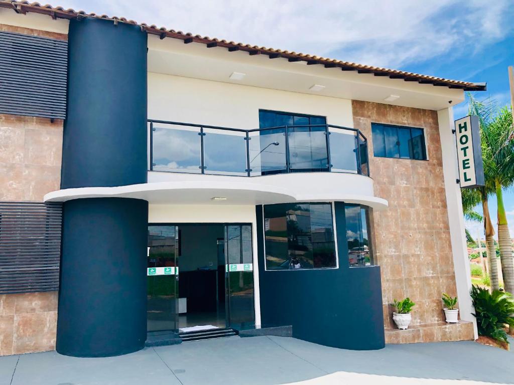 ein Gebäude mit blauen Säulen und einem Balkon in der Unterkunft Porto Verde Hotel in Lins