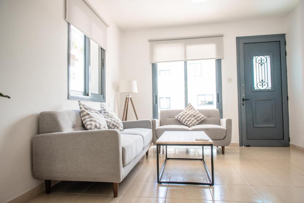 a living room with two couches and a table at Julipapas Gardens in Paphos