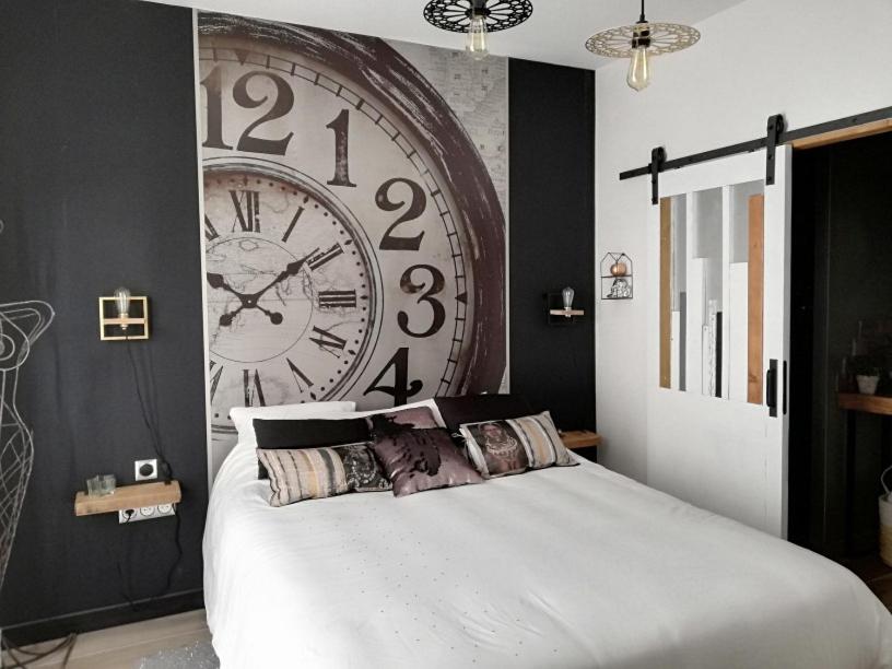 a bedroom with a large clock on the wall at Entre Honfleur et Etretat in Octeville-sur-Mer