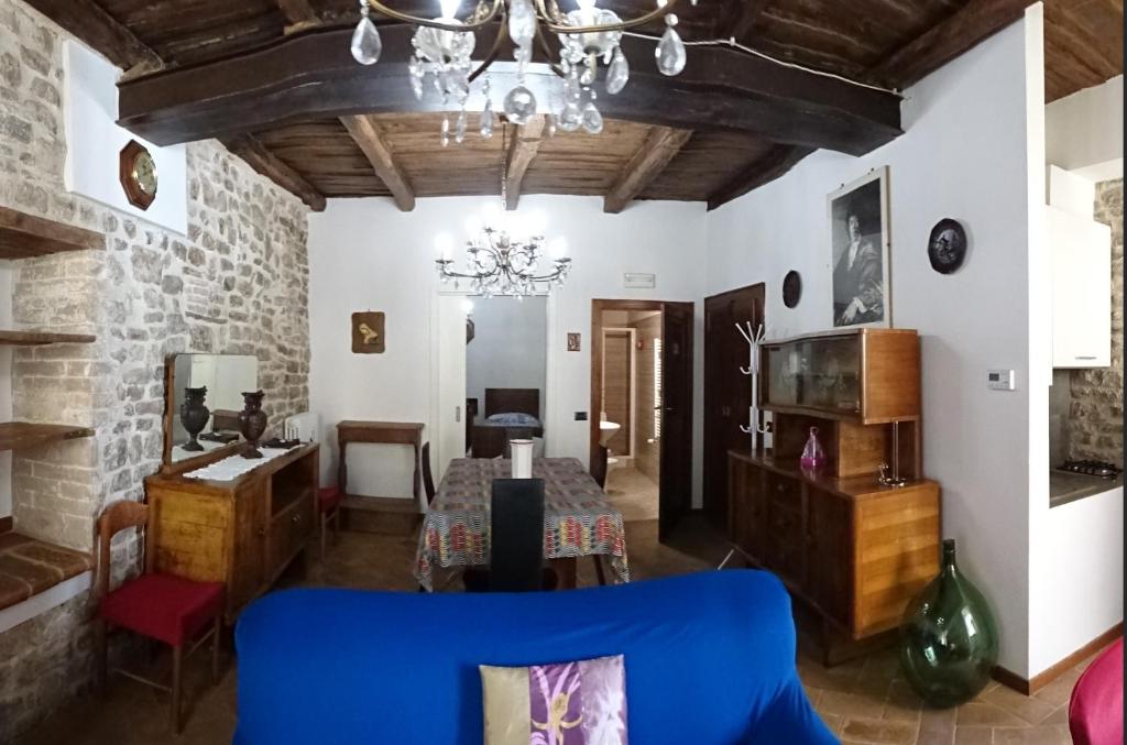 uma sala de estar com um sofá azul e uma mesa em Non ditelo al Duca - La Cappuccina em Spoleto