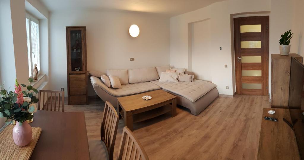 een woonkamer met een bank en een tafel bij Apartmán U Labe in Nymburk