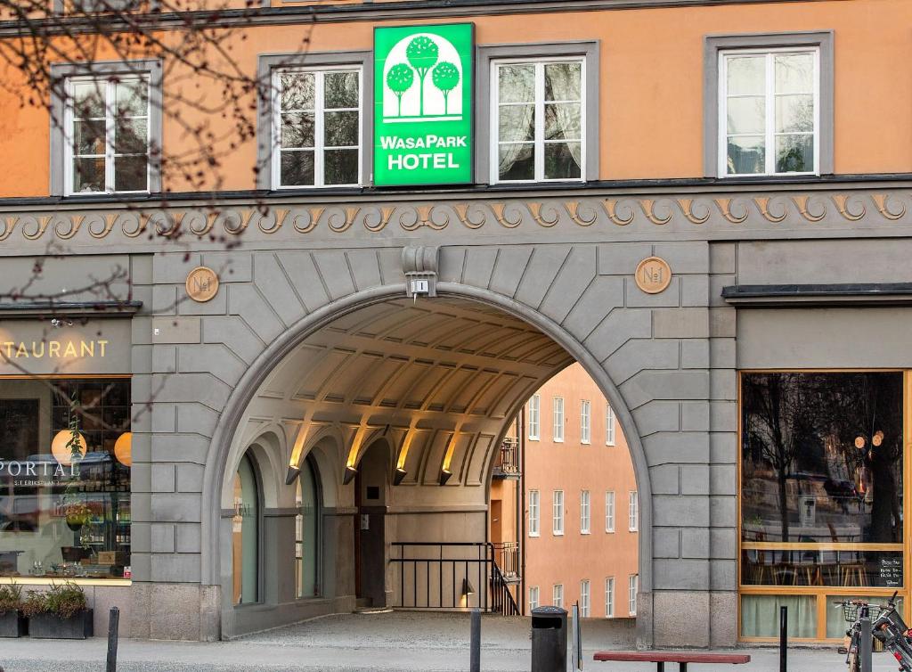 un edificio con un arco frente a una tienda en Wasa Park Hotel en Estocolmo