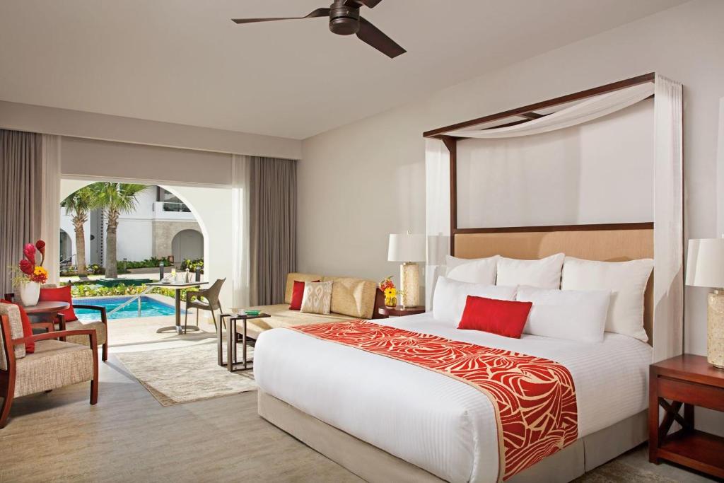 a bedroom with a large bed and a pool at Dreams Dominicus La Romana Resort & Spa in Bayahibe
