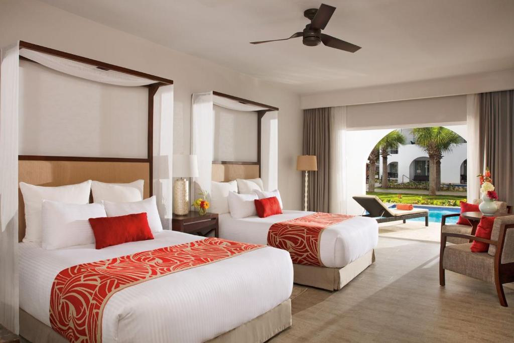 a hotel room with two beds and a living room at Dreams Dominicus La Romana Resort & Spa in Bayahibe