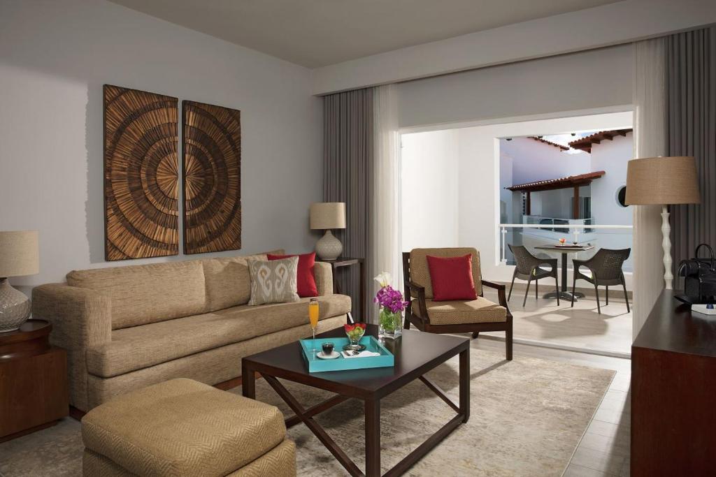a living room with a couch and a table at Dreams Dominicus La Romana Resort & Spa in Bayahibe