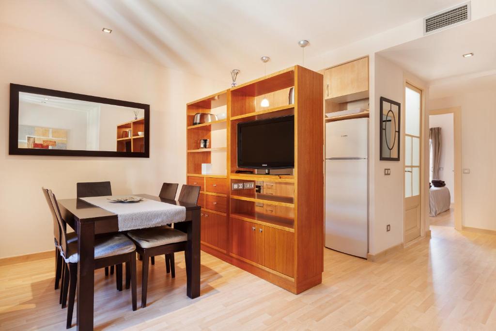 a living room with a dining room table and a television at Dream Gracia Apartments in Barcelona