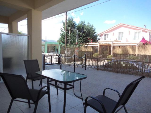 a patio with a table and chairs and a fence at Katerina Apartments near the Sea in Zakynthos Town