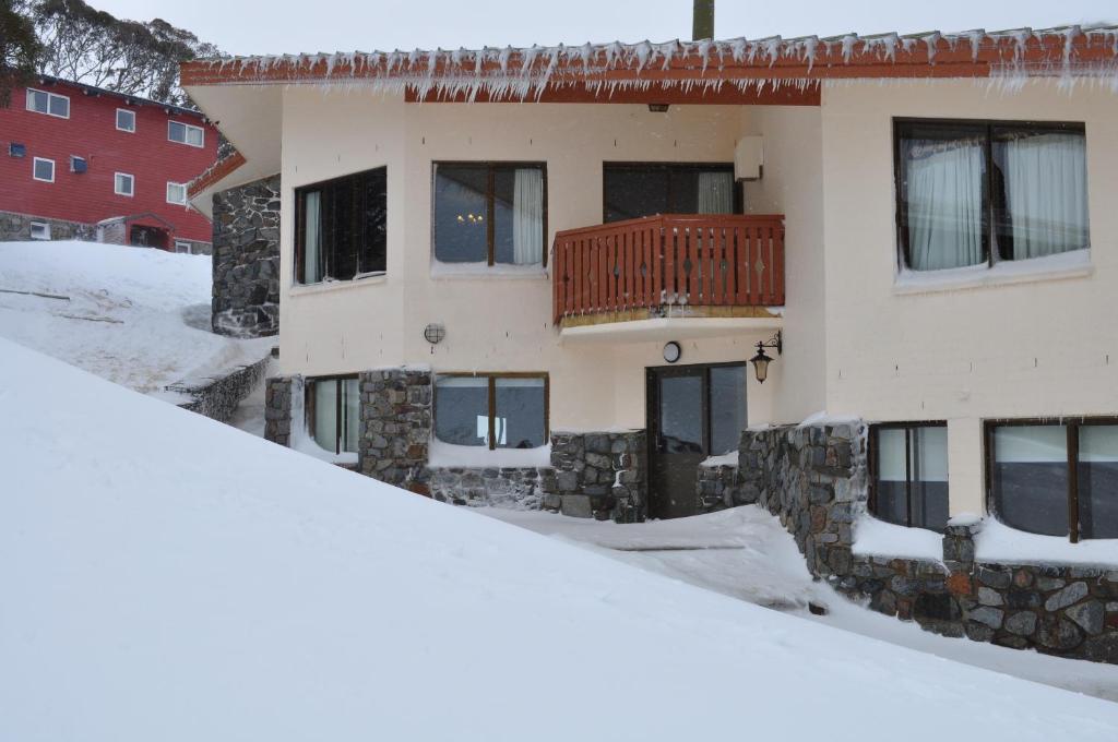 a building with a balcony in the snow at Salzburg Apartments in Perisher Valley