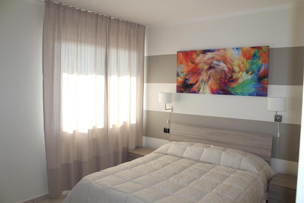a bedroom with a bed and a painting on the wall at Case Così Apartments - Verona in Verona