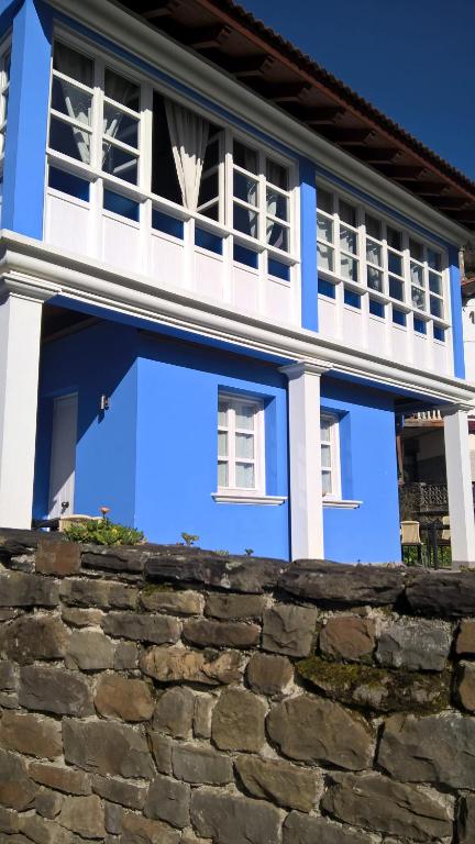 a blue and white house with a stone wall at Alborada De San Juan in Beleño