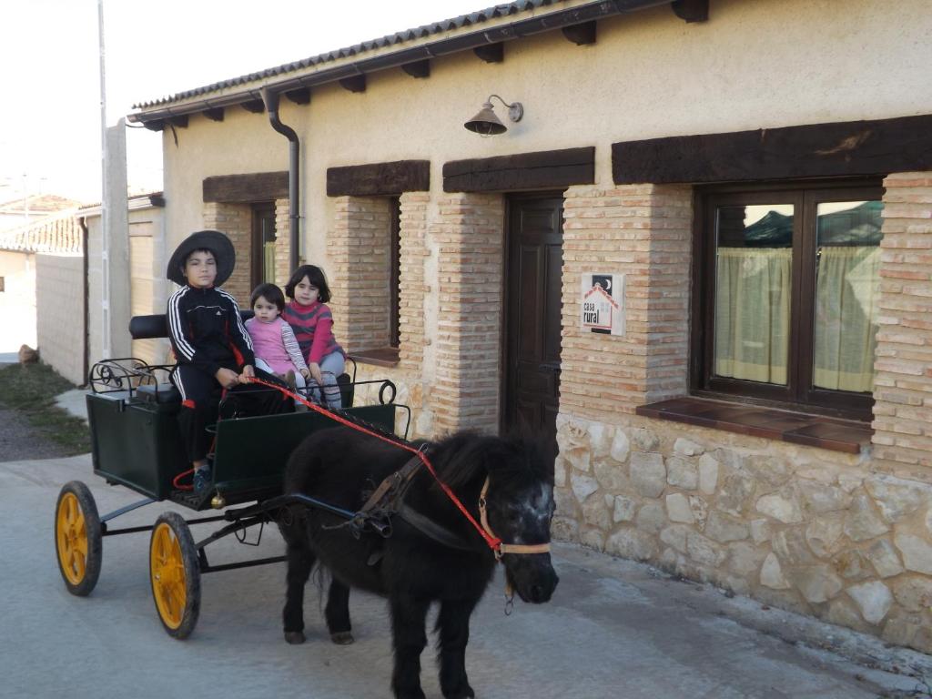 a group of people riding on a horse drawn carriage at CASA RURAL LA CASA DE LOS POLLOS in Turrubuelo