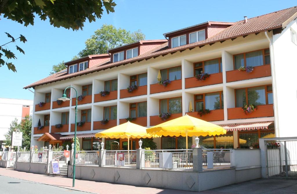 ein Hotel mit gelben Sonnenschirmen davor in der Unterkunft Hotel zum Kastell in Bad Tatzmannsdorf