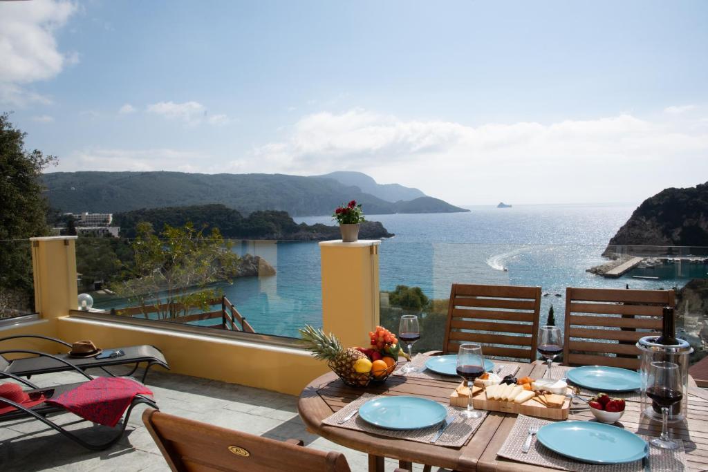 una mesa en un balcón con vistas al océano en Barbara's House, en Paleokastritsa