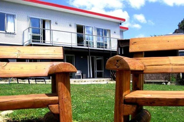 a wooden bench sitting in front of a building at Tombstone Motel, Lodge & Backpackers in Picton