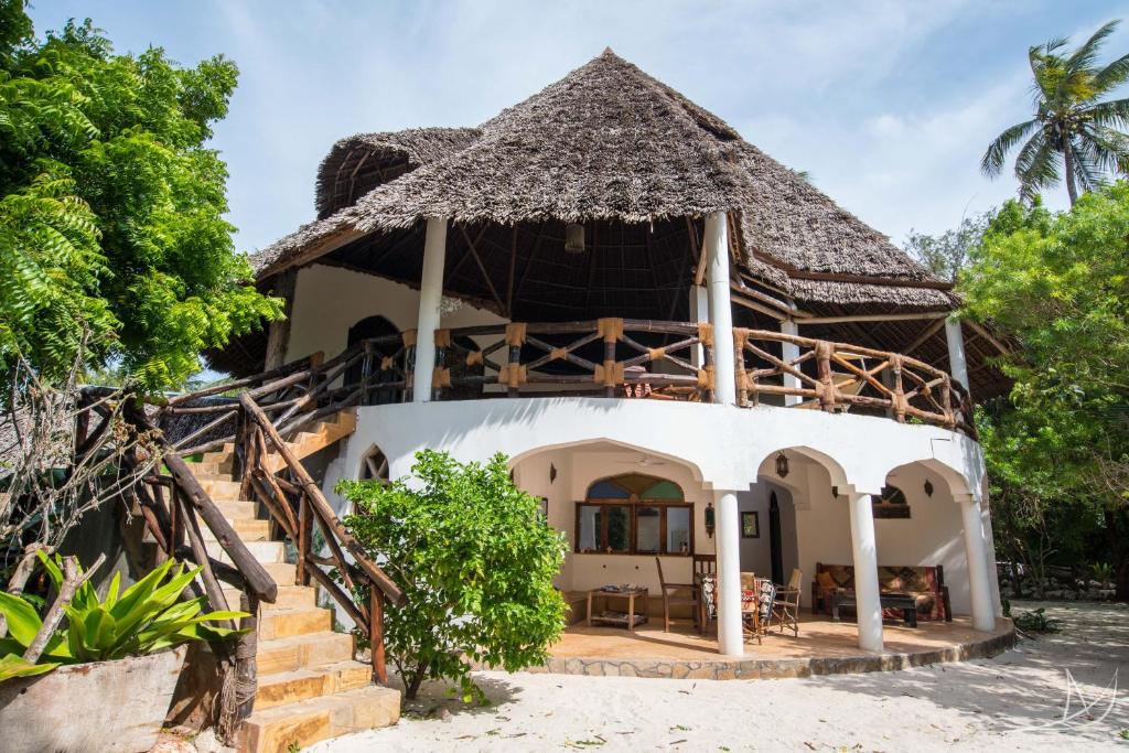 una casa en la playa con techo de paja en Casa Umoja, en Nungwi