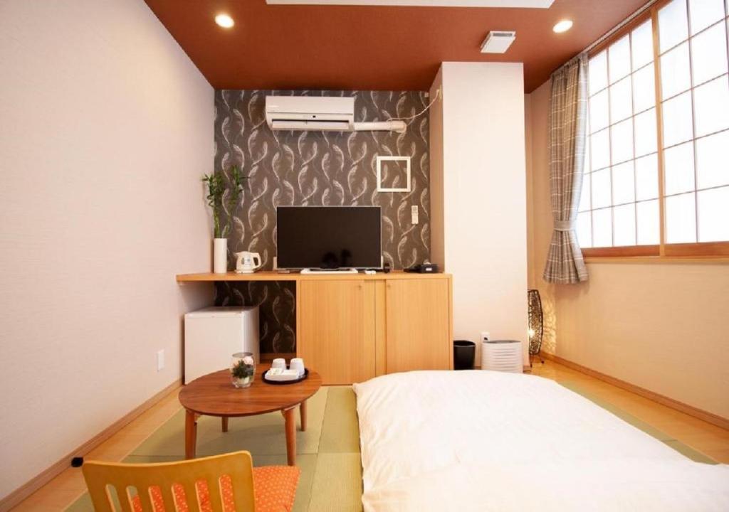 Arakawa-ku - Hotel / Vacation STAY 21943 في طوكيو: غرفة نوم بسرير وطاولة وتلفزيون