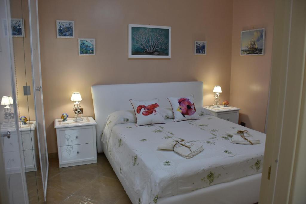 een slaapkamer met een wit bed met bloemen erop bij Il Corallo Rosso in Giardini Naxos