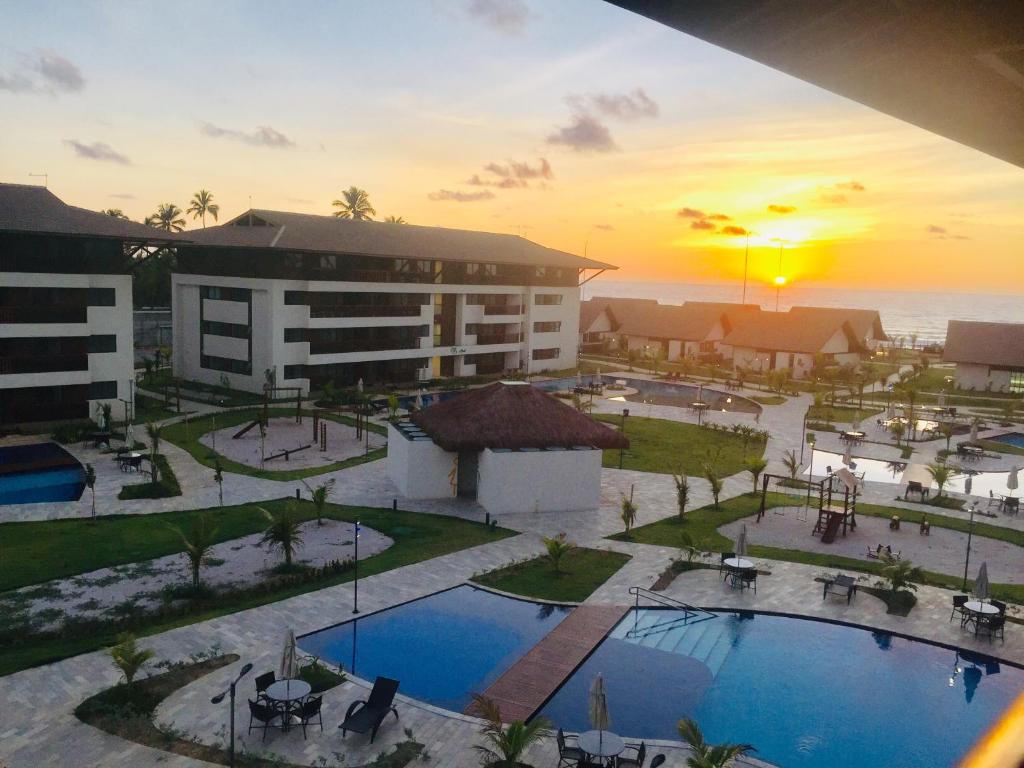 an aerial view of a resort with two pools at Flat Cupe Beach Living in Porto De Galinhas