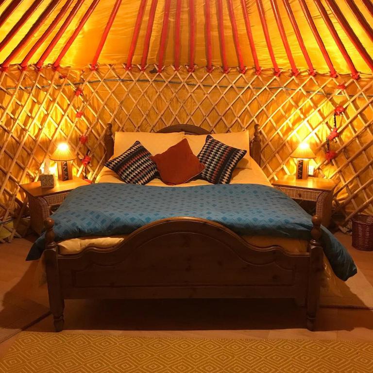 um quarto com uma cama numa tenda em McClure Yurt at Carrigeen Glamping em Kilkenny