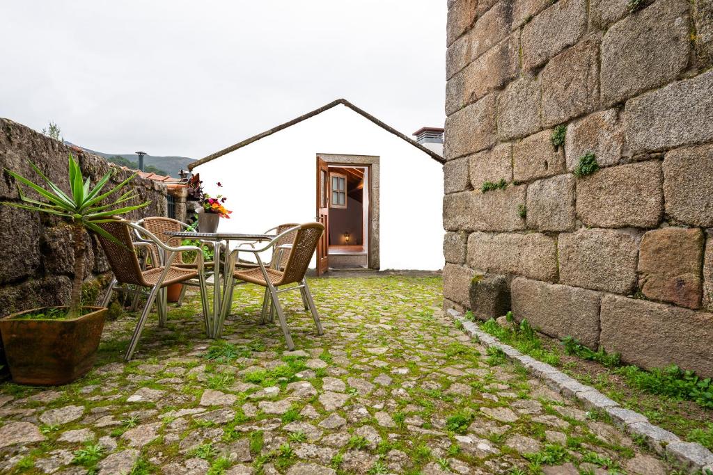 a patio with a table and chairs and a building at A casa do cervo in Vila Nova de Cerveira