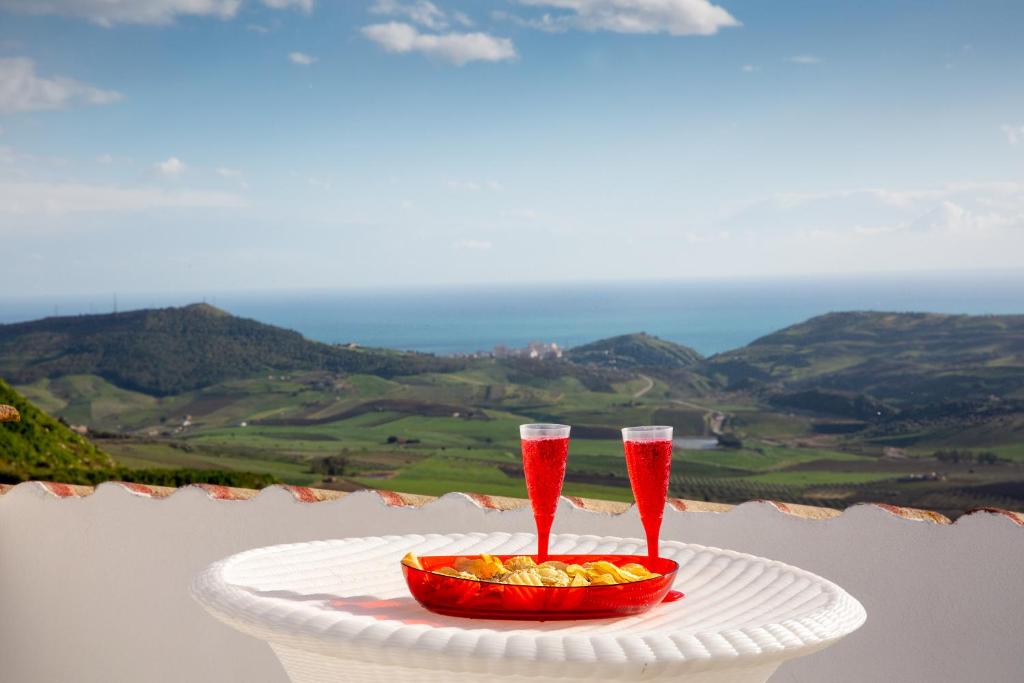 two wine glasses on a table with a bowl of fruit at Casa Belvedere in Agrigento