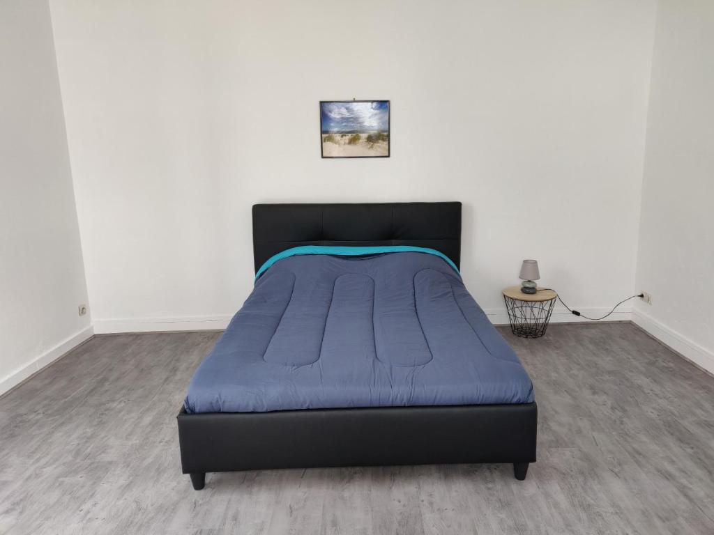een slaapkamer met een bed met een blauwe deken bij Hébergement Paquebot de Rêve in Saint-Nazaire
