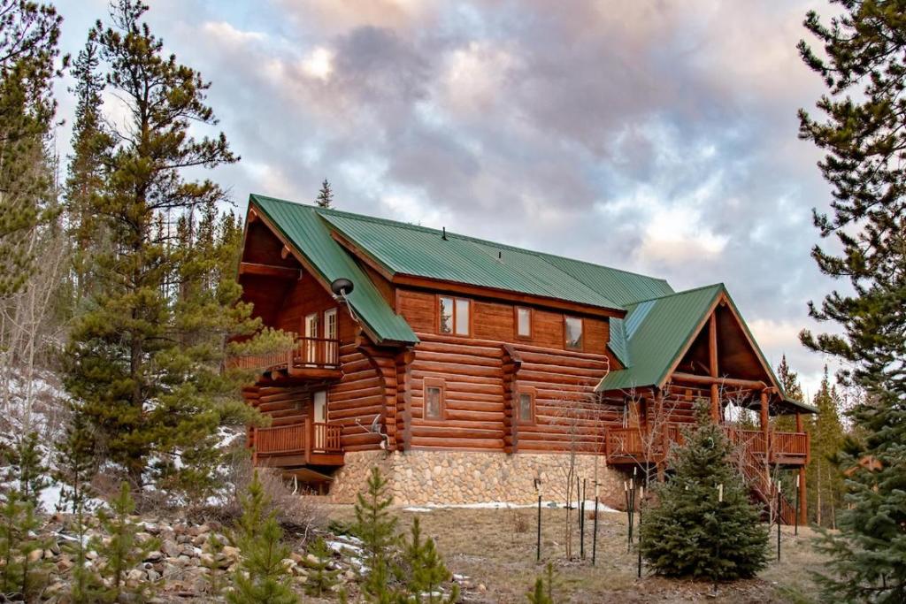 a large wooden cabin with a green roof at Elk Meadow Lodge in Breckenridge