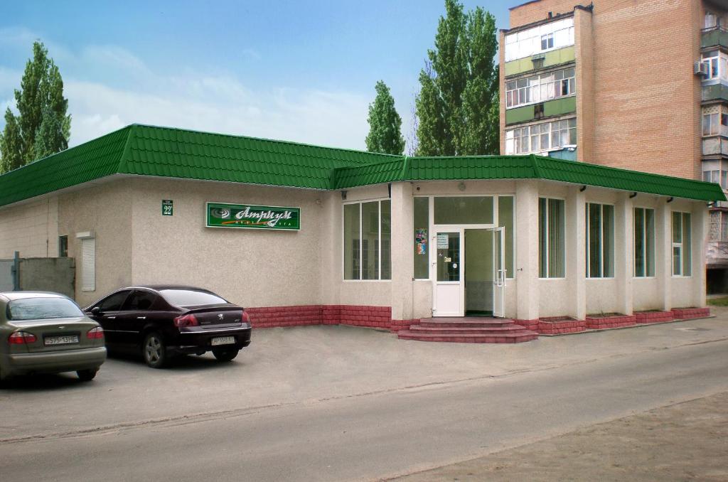 a building with a car parked in front of it at Atrium Hotel in Melitopol