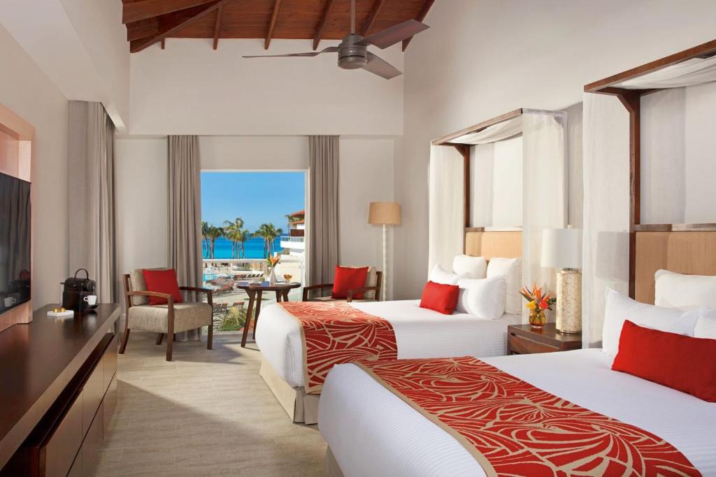 a hotel room with two beds and a balcony at Dreams Dominicus La Romana Resort & Spa in Bayahibe
