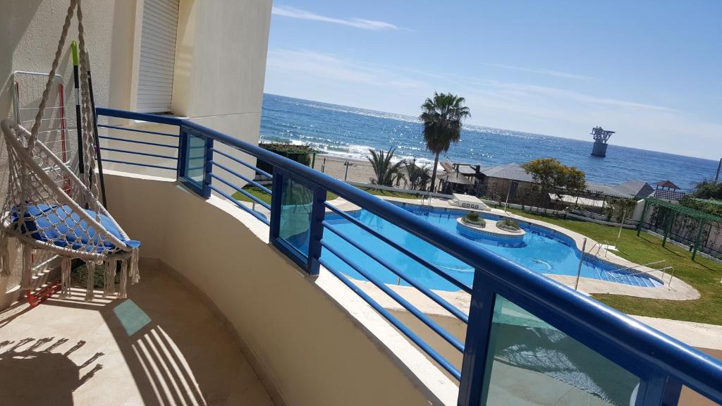 a balcony with a view of a swimming pool and the ocean at FIRST Beach line in Marbella
