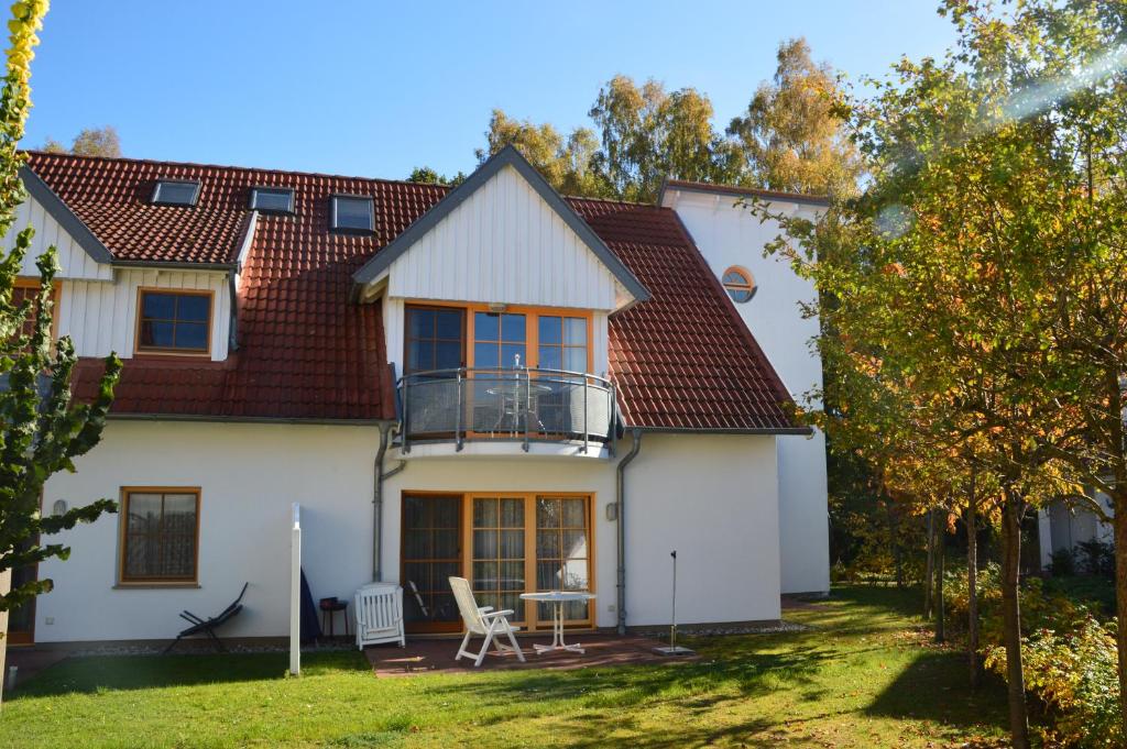 a white house with a balcony and a yard at Ferienzeit in Zingst
