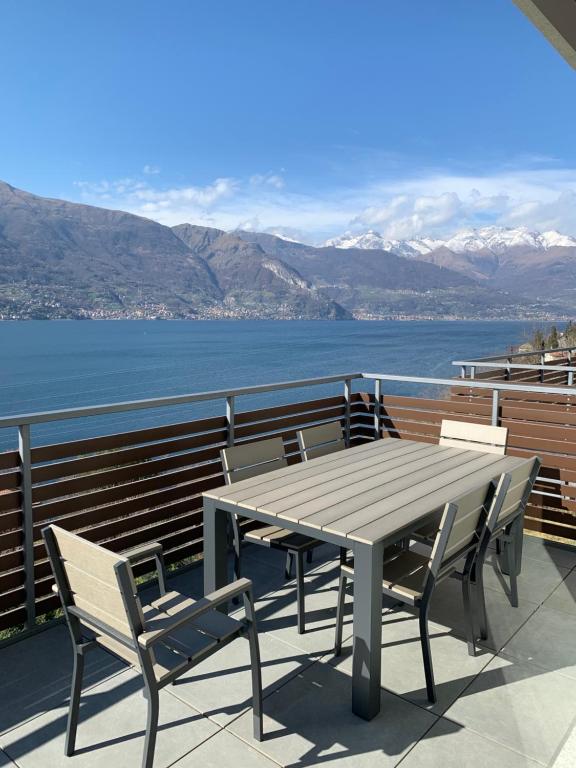 a table and chairs on a balcony with a view of the water at Casa MICHI in Dervio